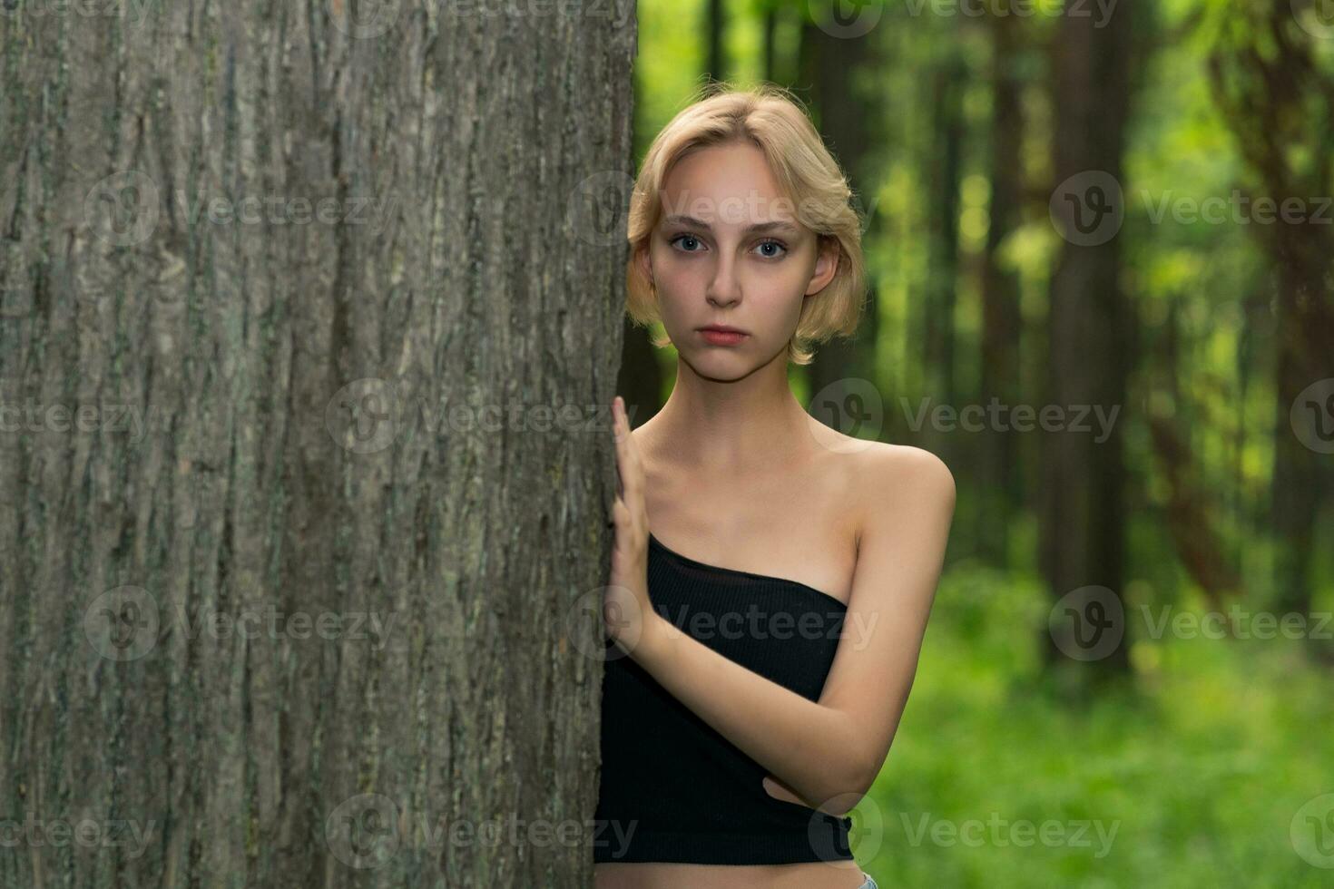 mooi jong vrouw De volgende naar de boom in de Woud foto