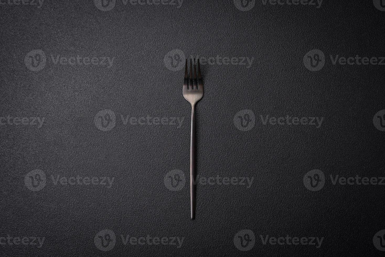 keuken vork gemaakt van staal Aan een donker getextureerde achtergrond foto