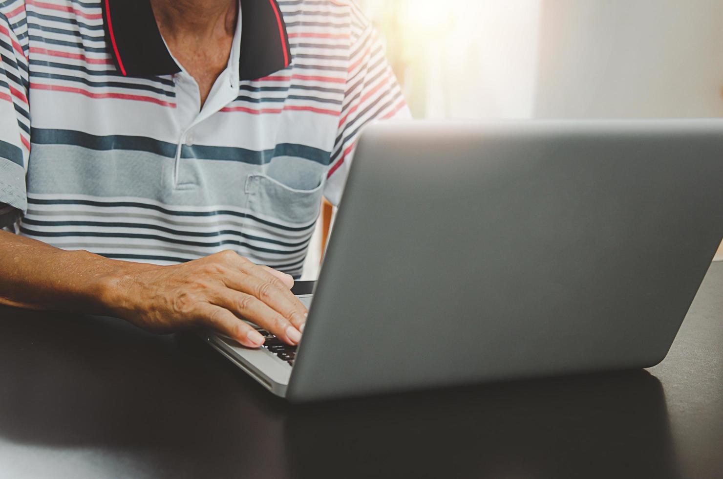 man hand met behulp van computer laptop op tafel thuis, zoeken naar informatie op internet surfen op het web, werken vanuit huis foto