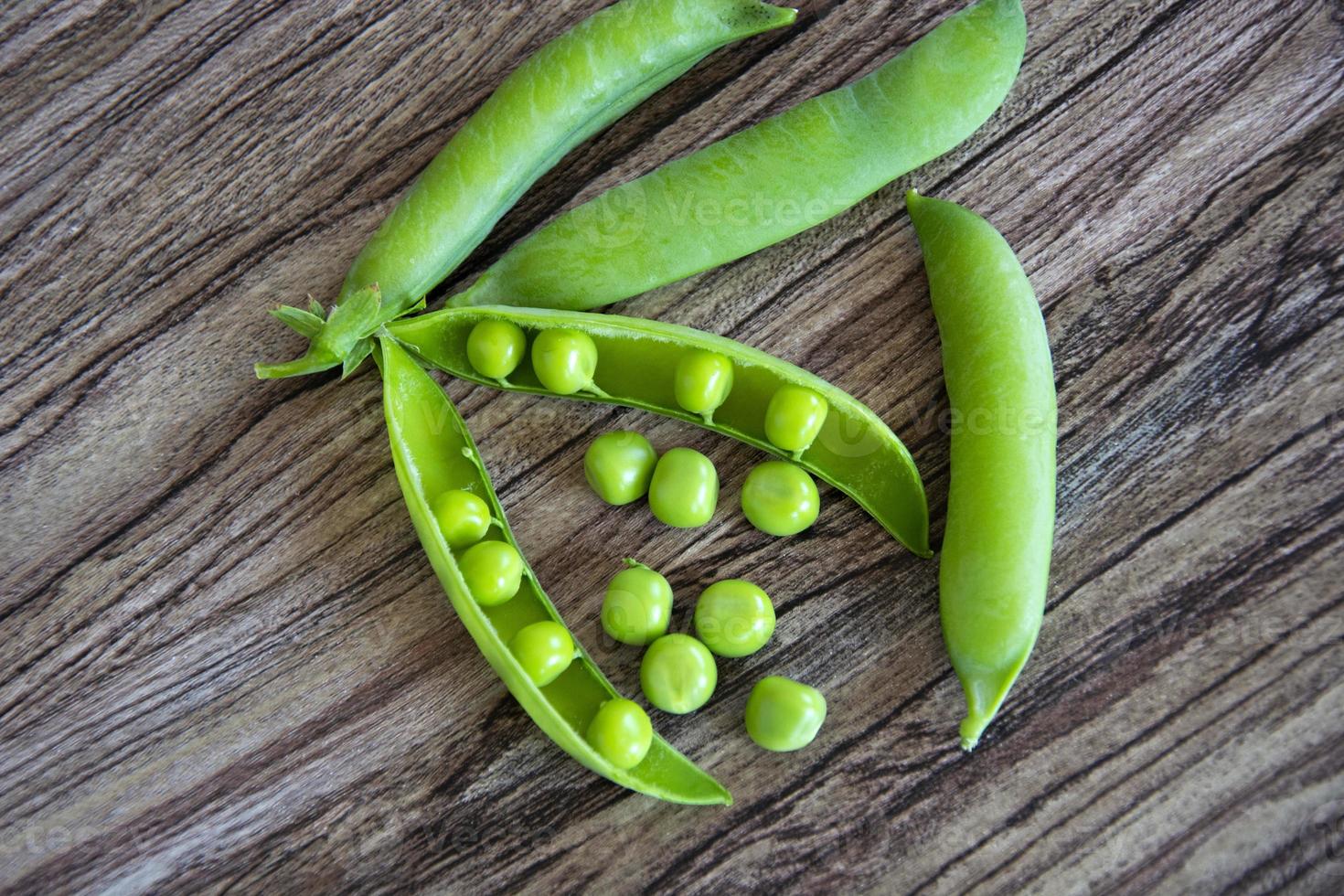 groene erwten peulen. klimplanten met peulen. erwten in peulen liggen op een houten achtergrond. uitzicht van boven. foto