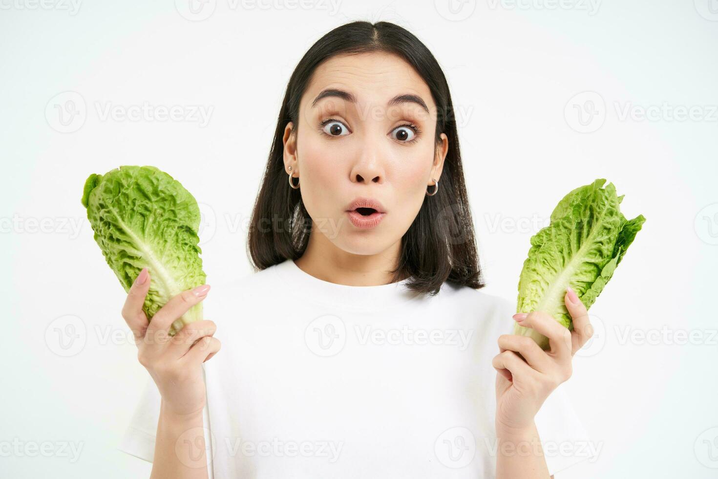 portret van vrouw met verrast gezicht, Holding kool, sla bladeren en looks versteld staan, groeit groenten in eigen tuin, wit achtergrond foto