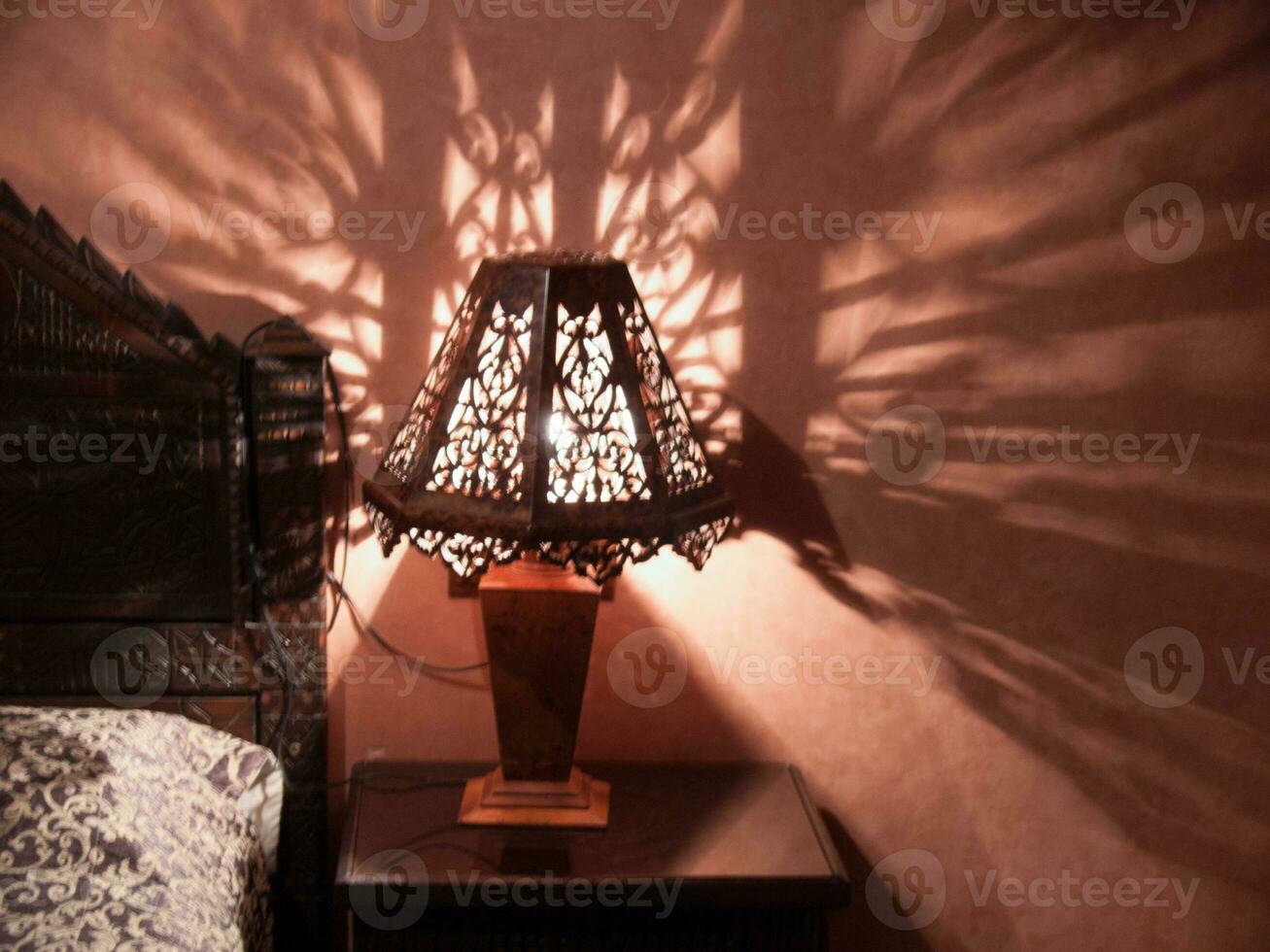 een bed met een lamp Aan het en een schaduw Aan de muur foto