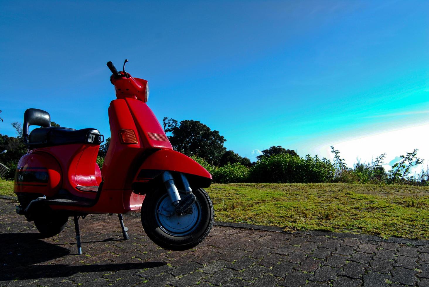 vintage scooter stands en blauwe lucht foto