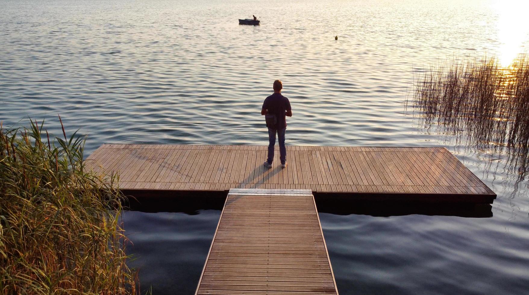 man die op een houten pier staat foto