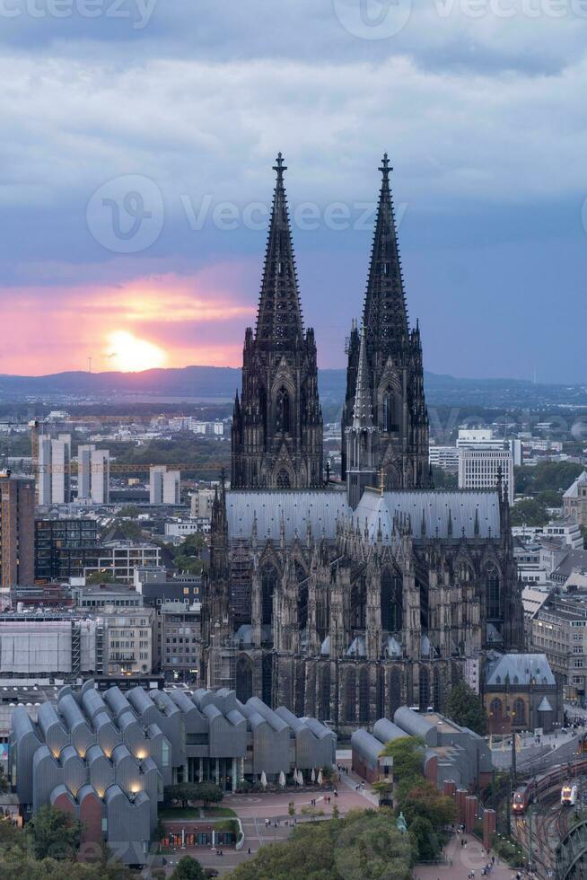 dramatisch storm wolken over- Keulen kathedraal en hohenzollern brug in de zonsondergang foto