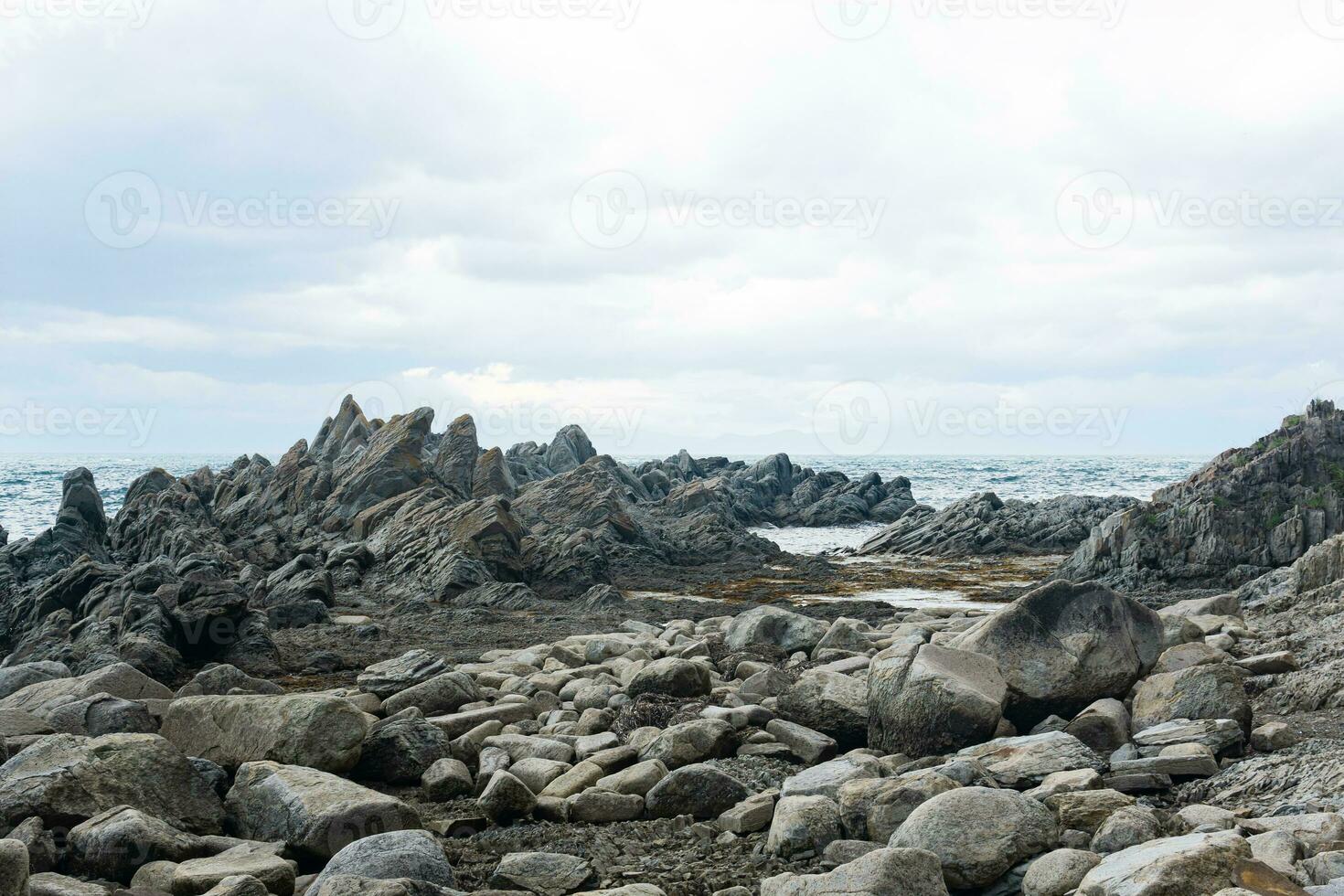 scherp gekarteld basalt rotsen Aan de zee kust, kaap stolbchaty Aan kunashir eiland foto