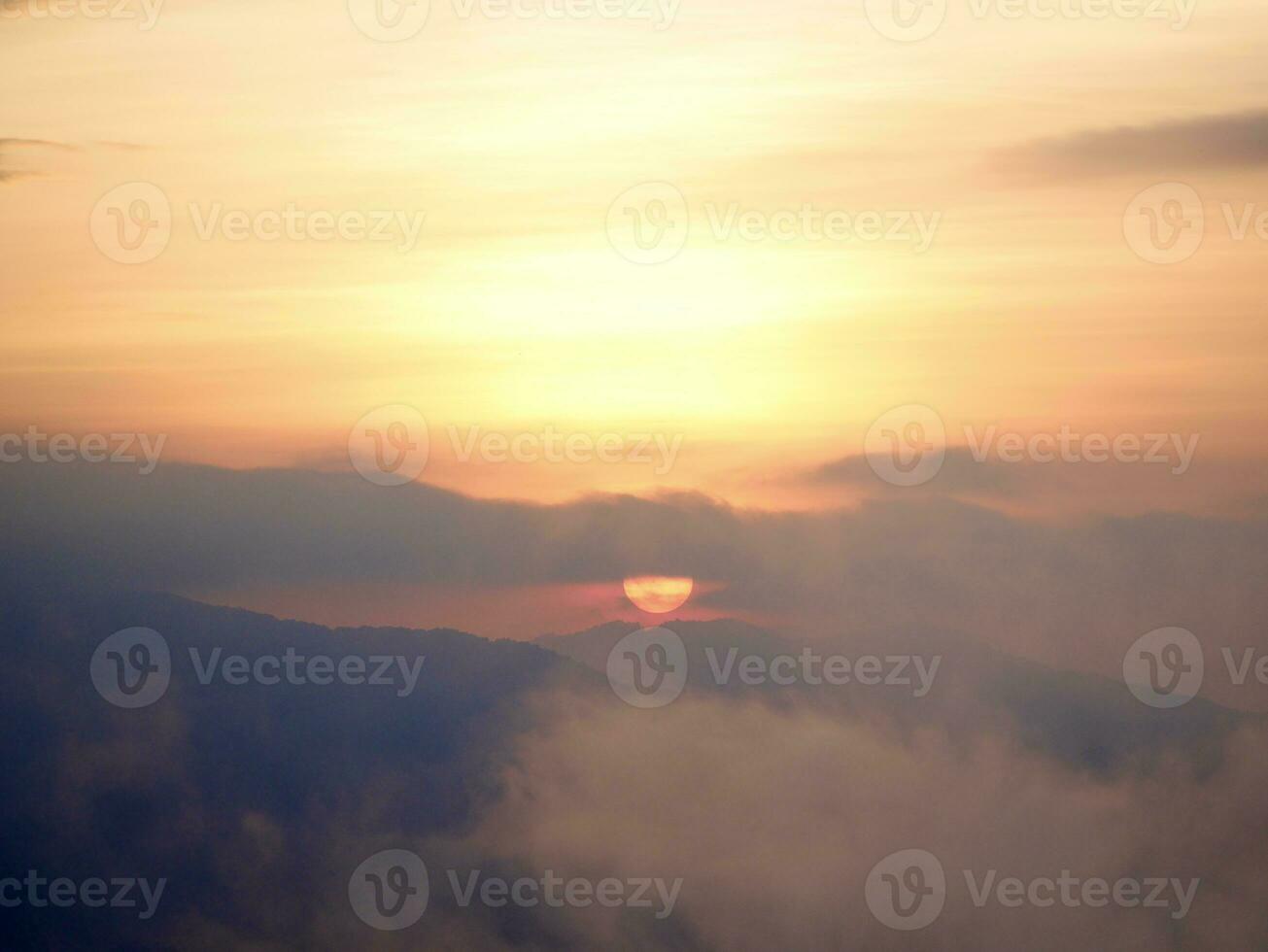 de de nevel stromen door de berg Woud, zon schijnend in tropisch Woud, de nevel drijft door berg ruggen in de ochtend, langzaam drijvend mist blazen Hoes Aan de top van berg foto