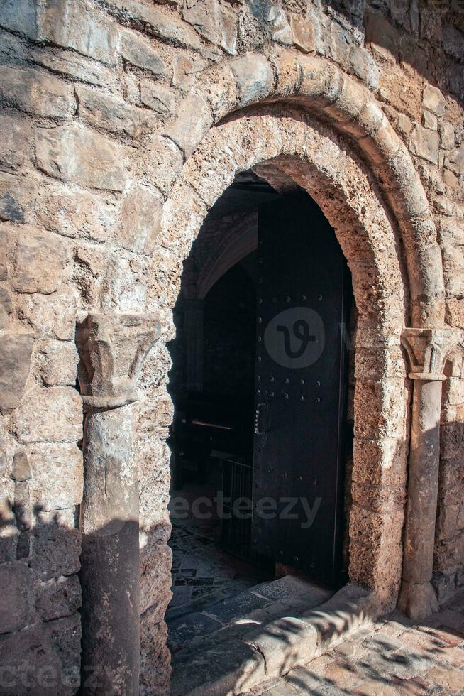 zwart deur leidend in oude kerk foto. beige steen getextureerde muur fotografie. Ingang met twee luiken. foto