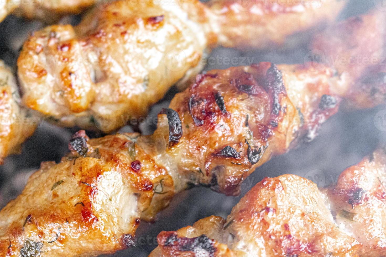 Russische sjasliek met spiesjes op een ronde grill foto