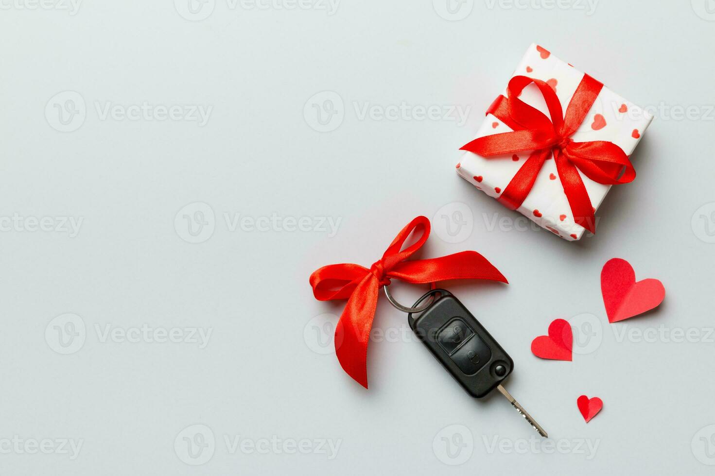 zwart auto sleutel in een Cadeau doos met een lint en rood hart Aan gekleurde achtergrond. Valentijn dag samenstelling top visie foto