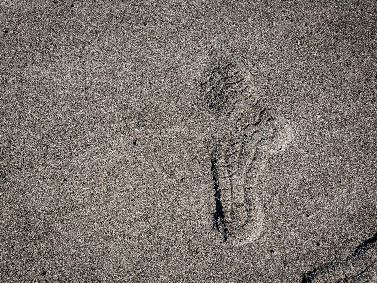 zolen van schoenen Aan zwart zand foto