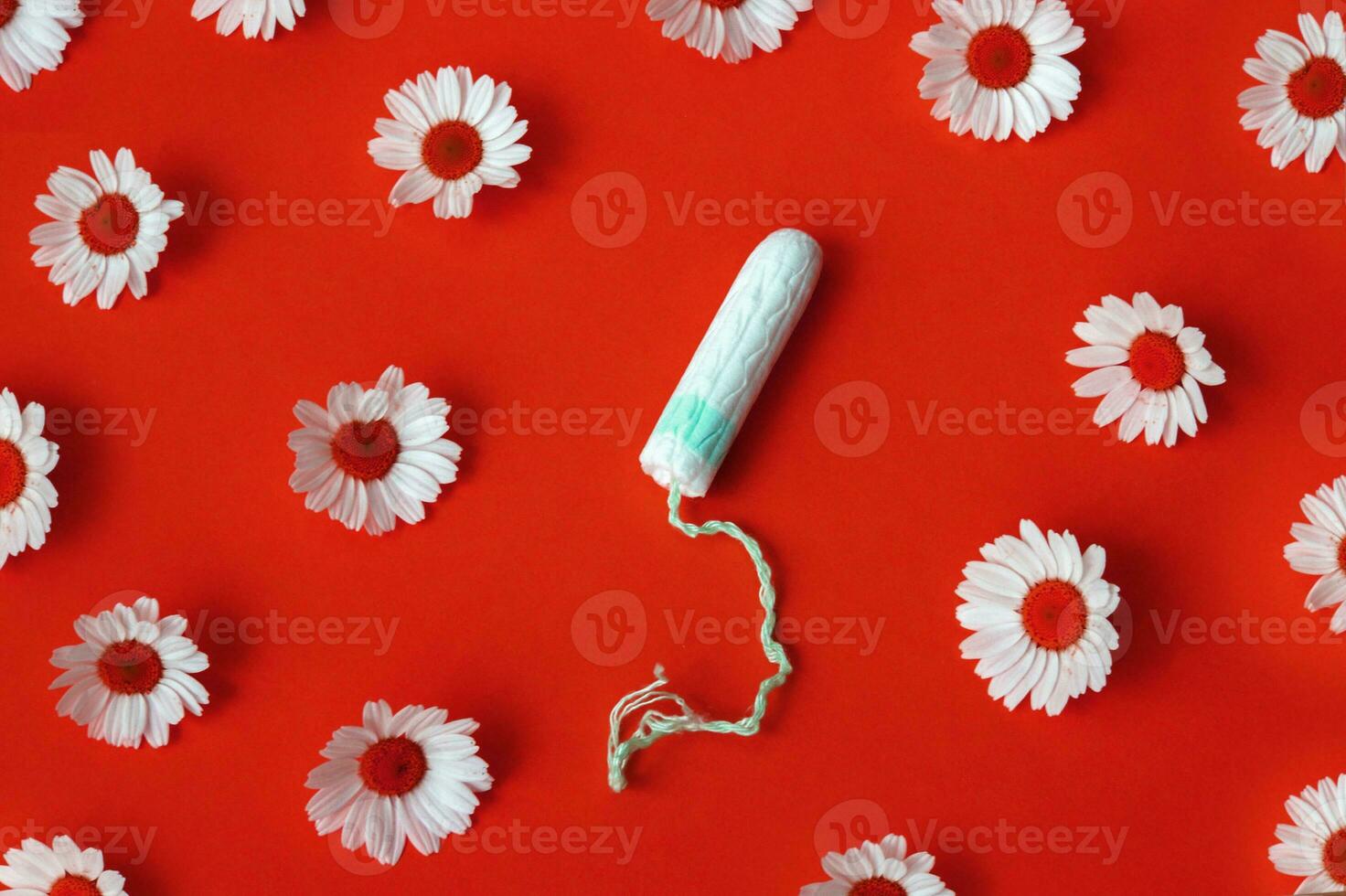 hygiënisch medisch vrouw tampon met kamilles in de omgeving van Aan een rood achtergrond. foto