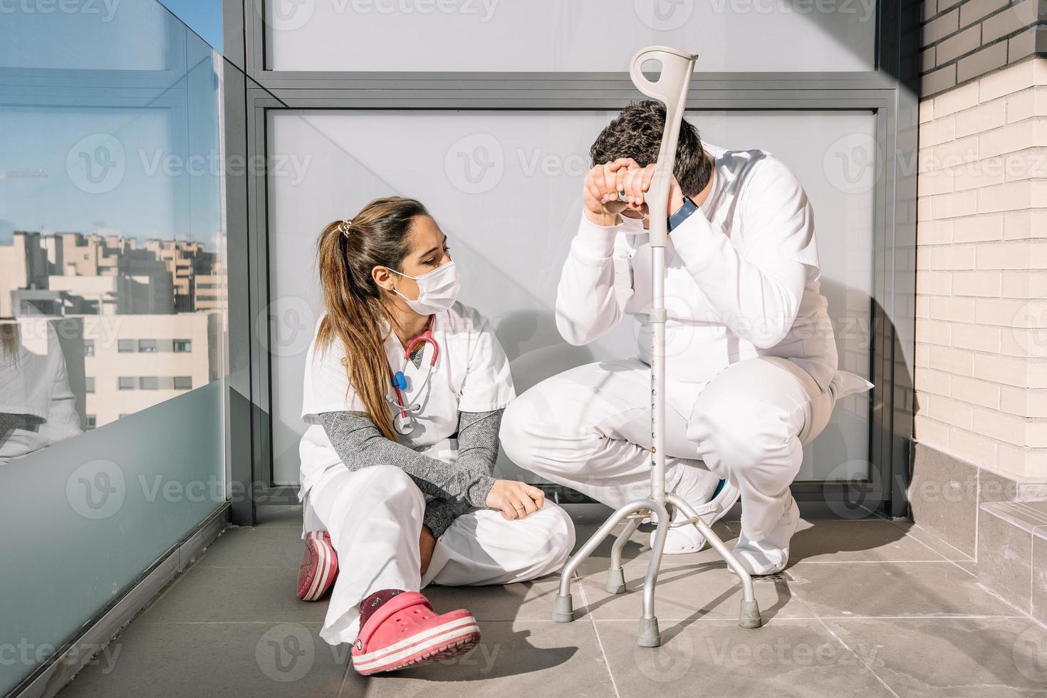 vermoeide artsen ontspannen op terras tijdens werkdag foto