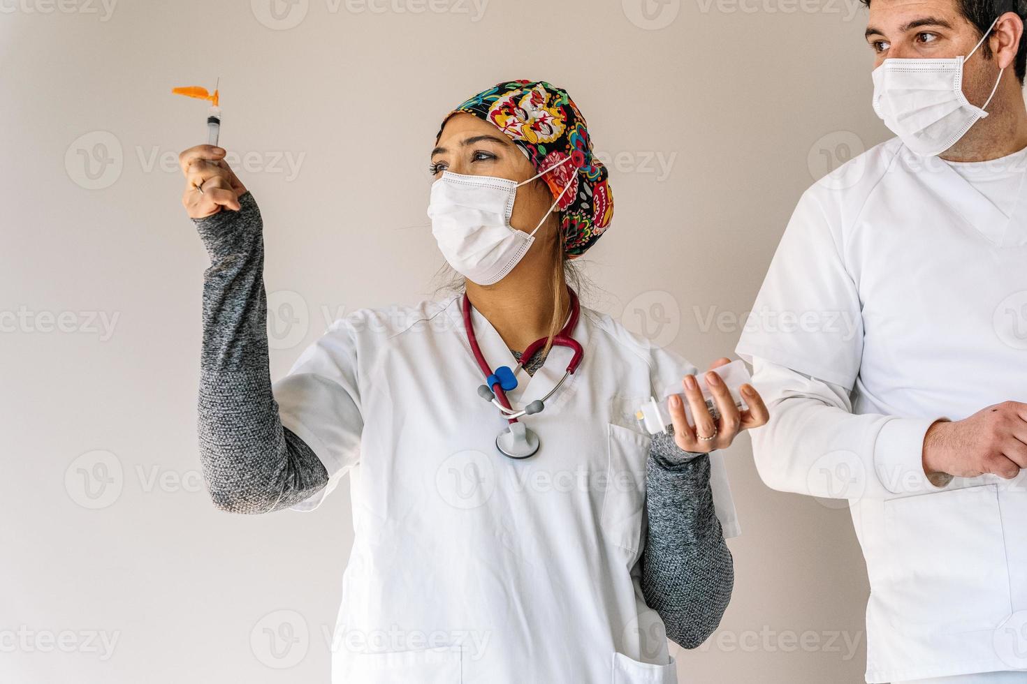 lachende arts met spuit in medische kamer foto
