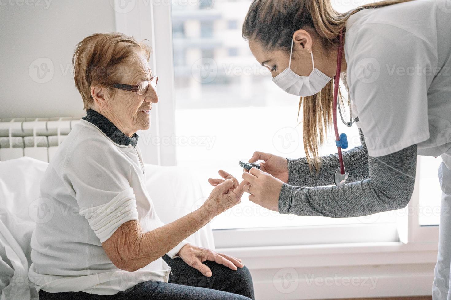 arts die de bloeddruk van hogere vrouw diagnostiseert foto