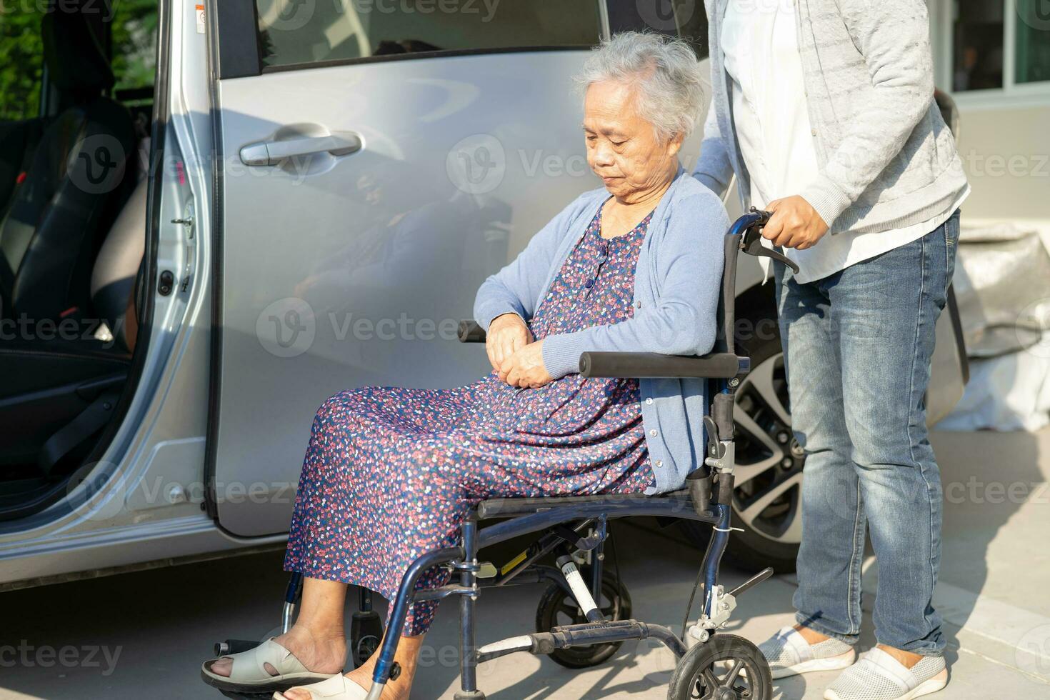 verzorger helpen en ondersteuning Aziatisch ouderen vrouw zittend Aan rolstoel bereiden krijgen naar haar auto naar reizen in vakantie. foto