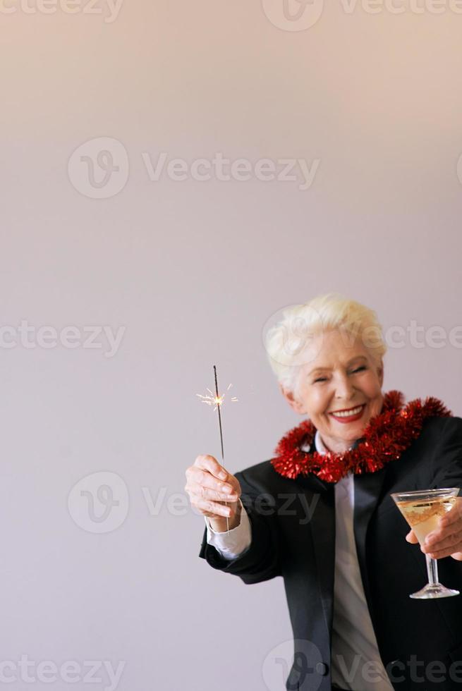 stijlvolle volwassen senior vrouw in smoking nieuwjaar vieren. plezier, feest, stijl, feestconcept foto