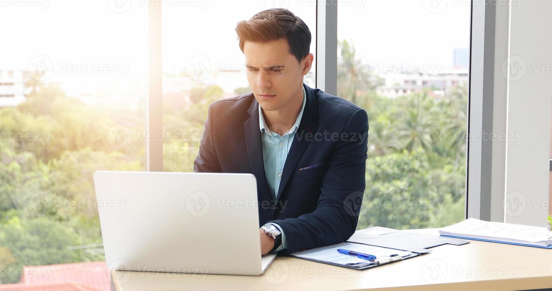 zakenlieden die een notebook gebruiken en serieus zijn over het verrichte werk tot de hoofdpijn foto