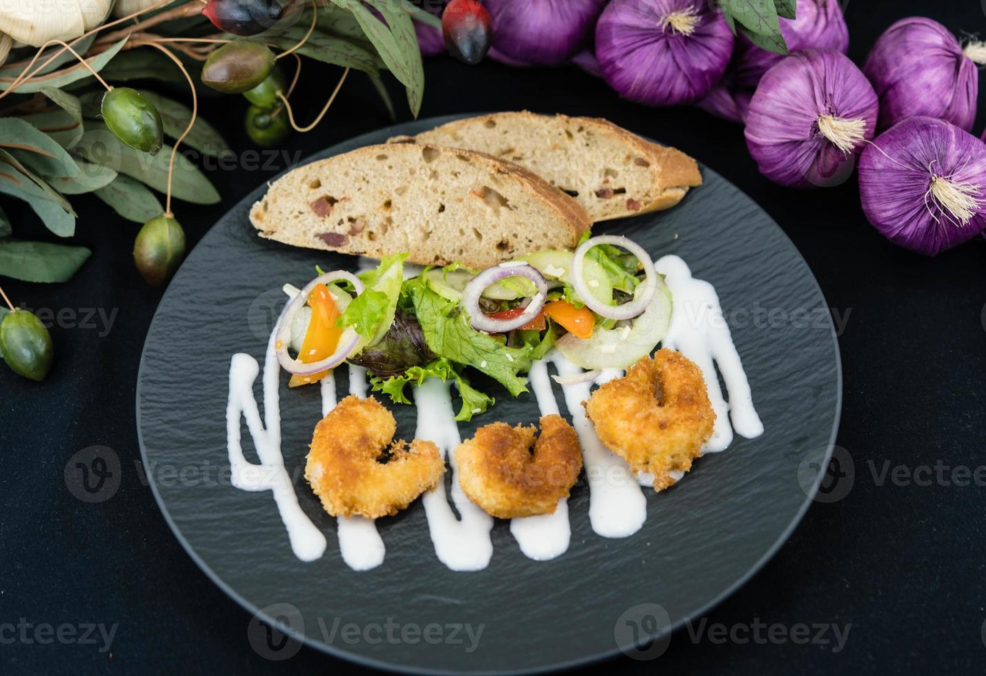 Krokant gepaneerde en gebakken garnalen met salade foto