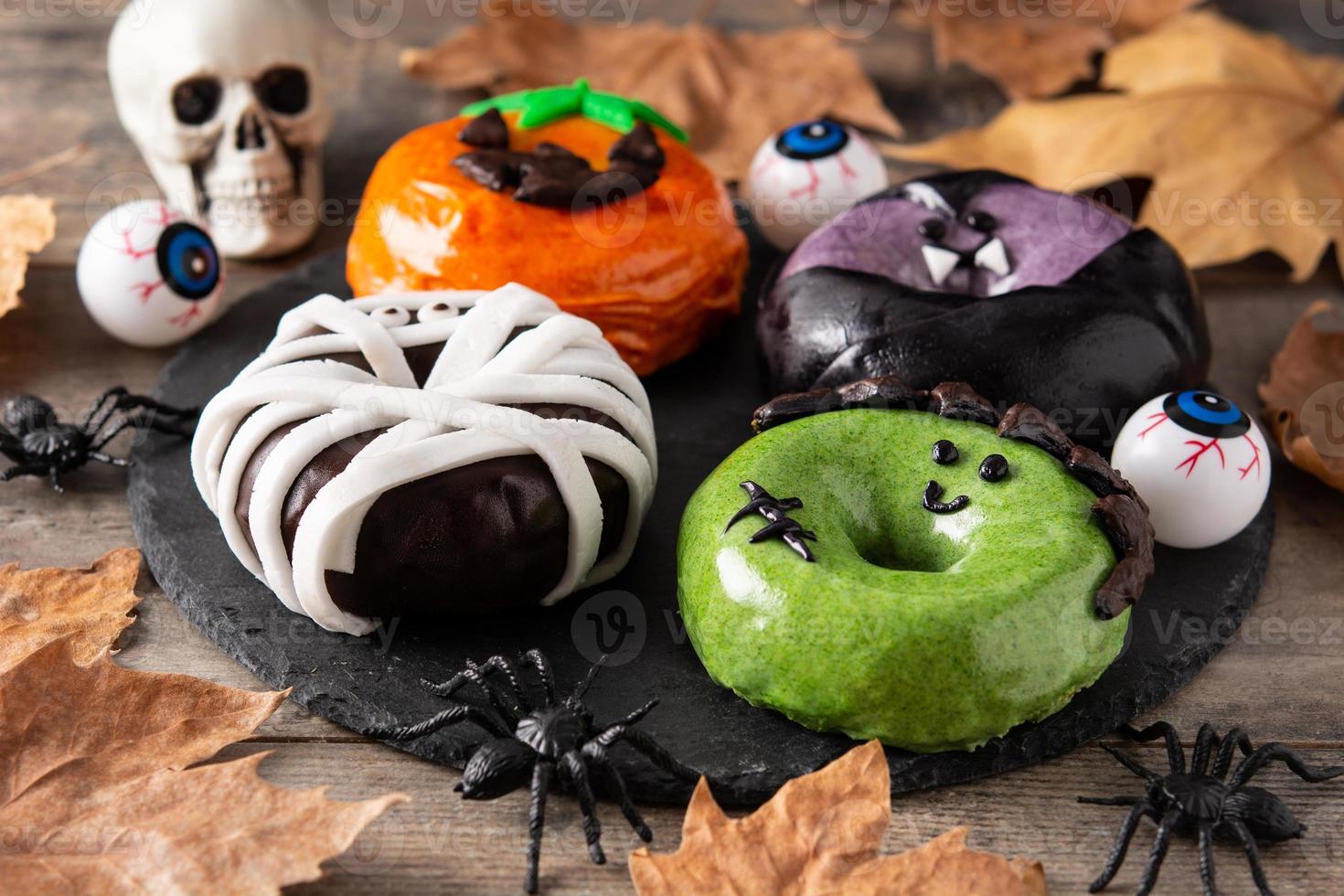 assortiment halloween donuts en herfstbladeren foto
