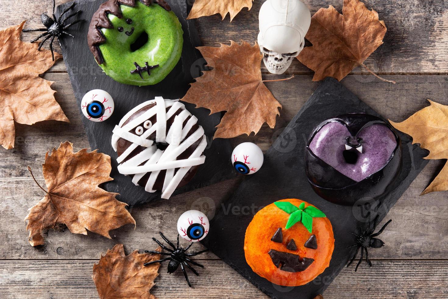 assortiment halloween donuts en herfstbladeren foto