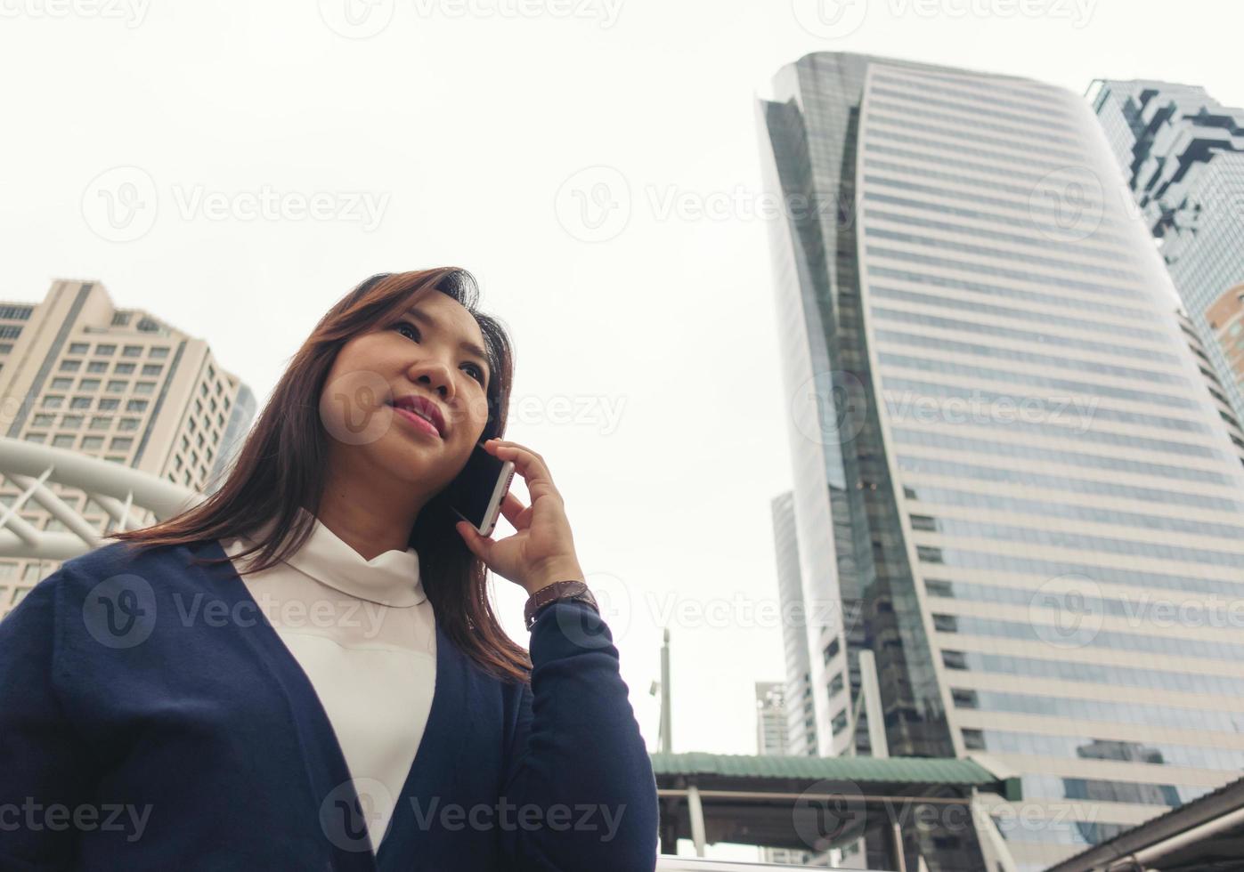 vrouw die buiten loopt en op mobiele telefoon praat foto