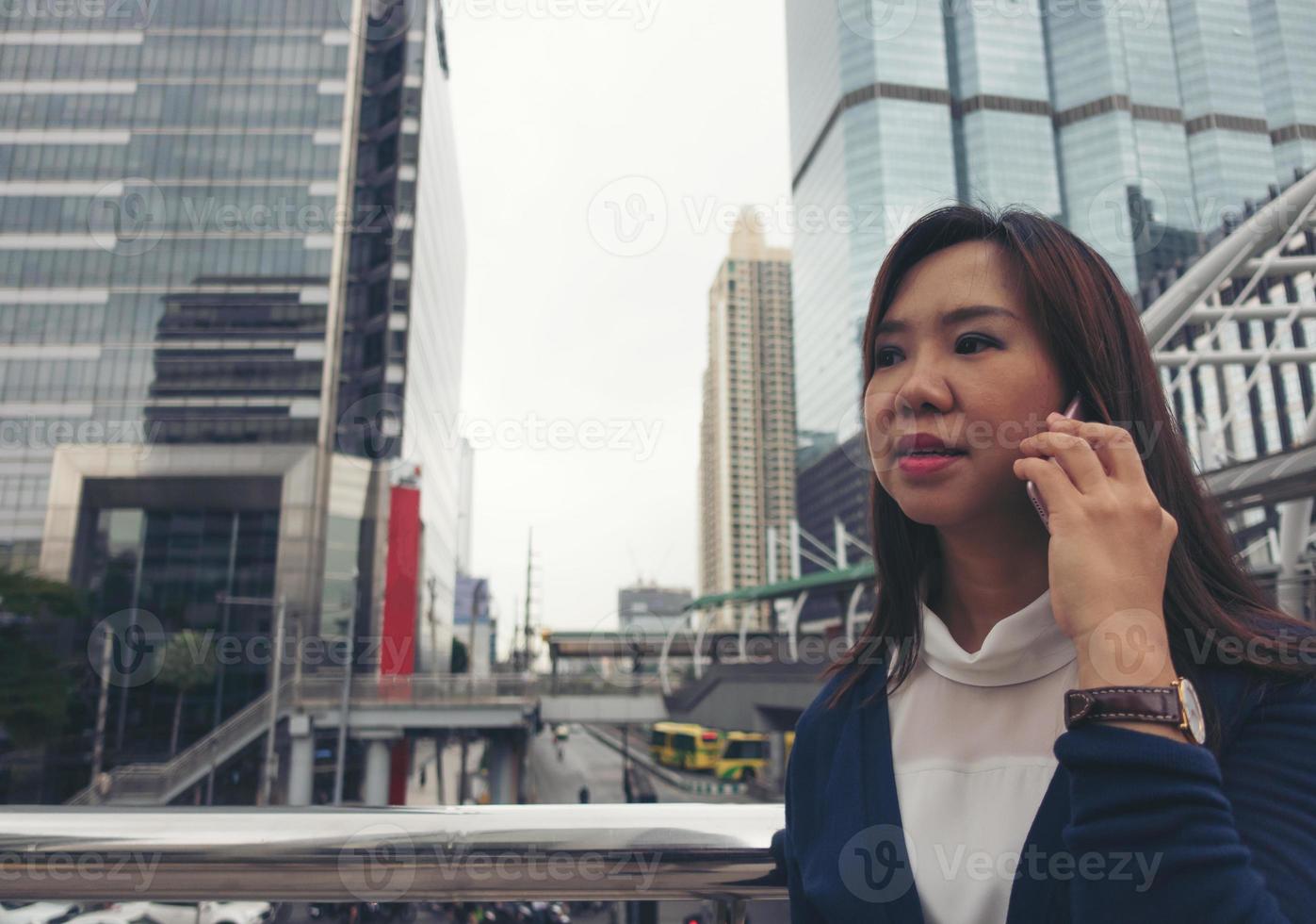 vrouw die buiten loopt en op mobiele telefoon praat foto