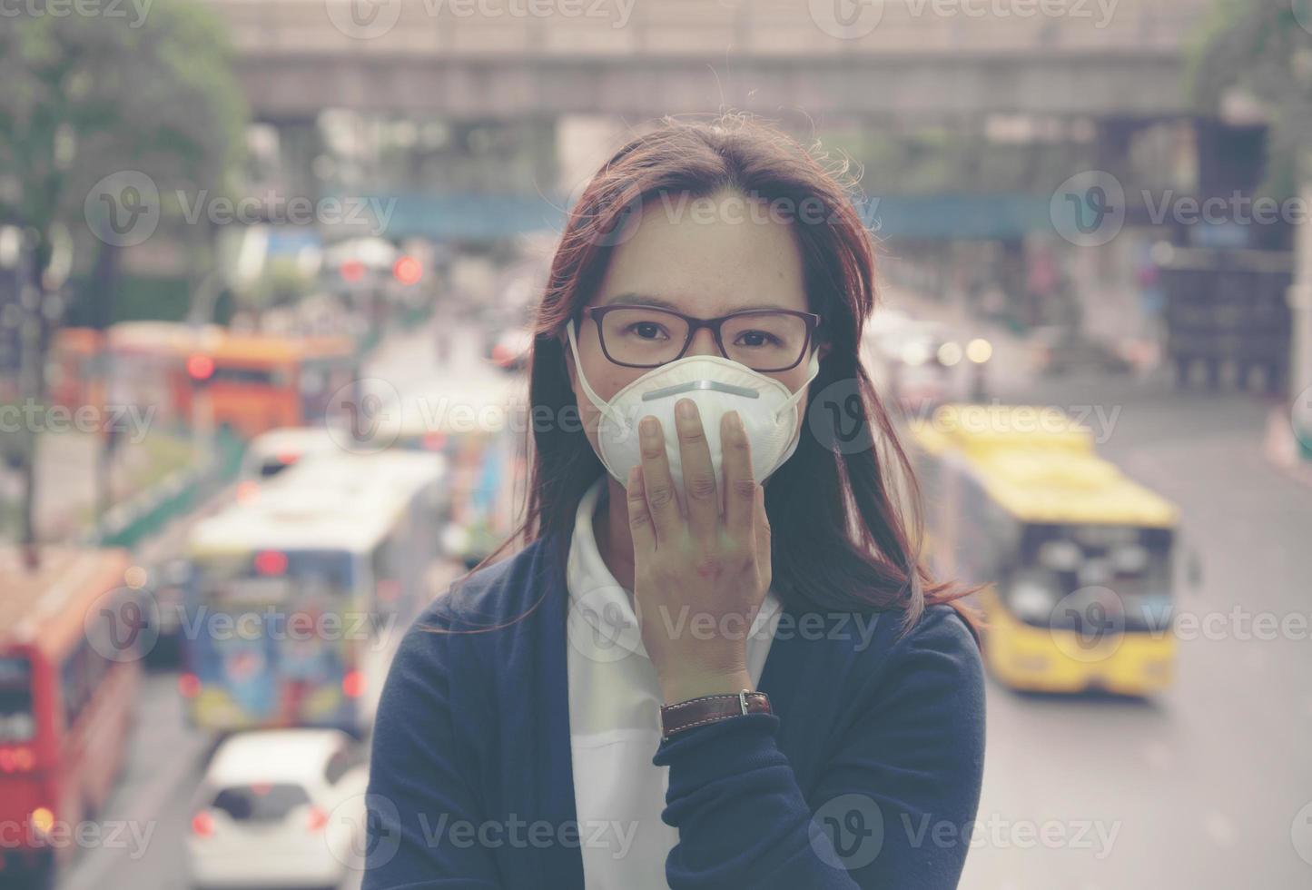 vrouw die beschermend masker draagt in de stadsstraat foto
