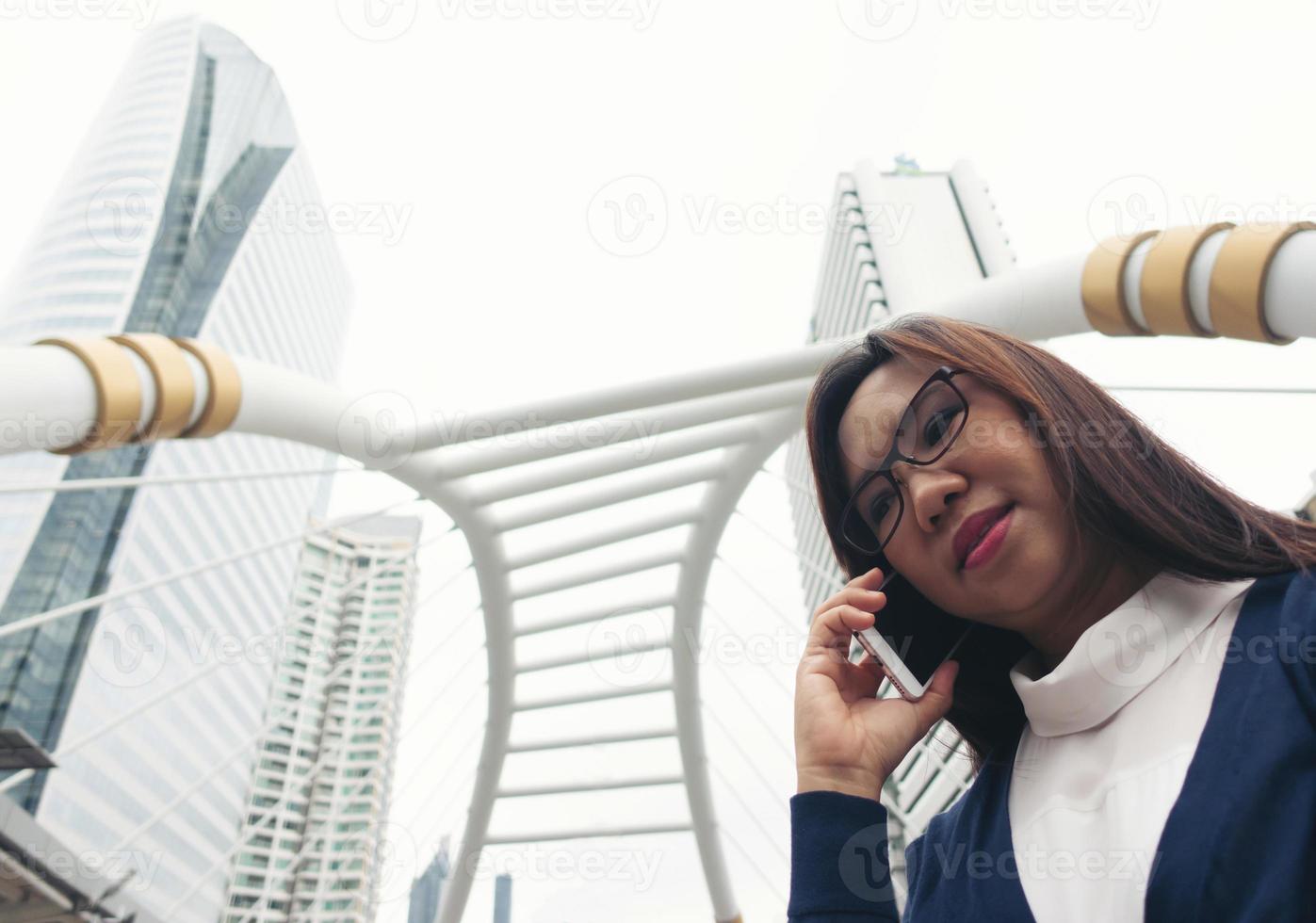 vrouw die buiten loopt en op mobiele telefoon praat foto