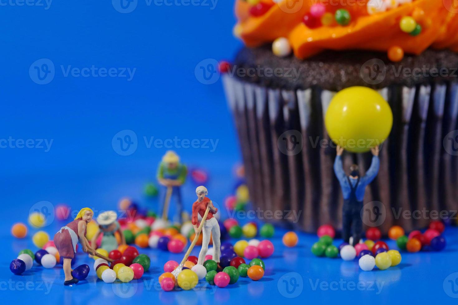 plastic mensen die een rommelige cupcake opruimen foto