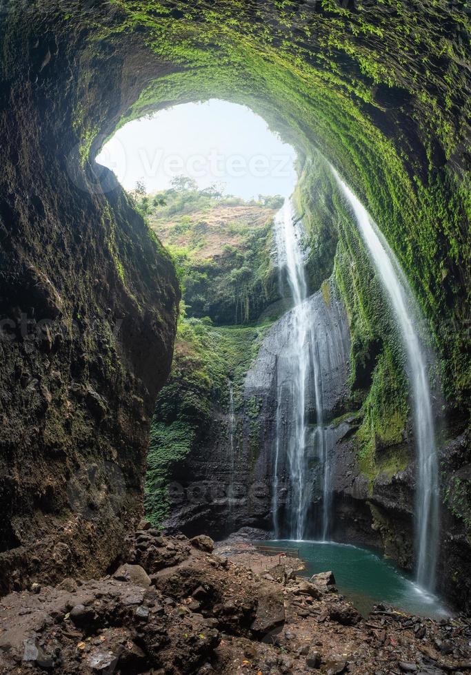 majestueuze waterval die op rotsachtige klip in tropisch regenwoud stroomt foto