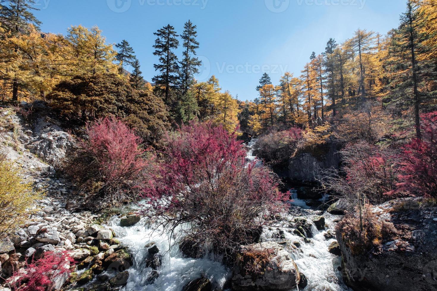 kleurrijke waterval in herfstbos bij yading-natuurreservaat foto