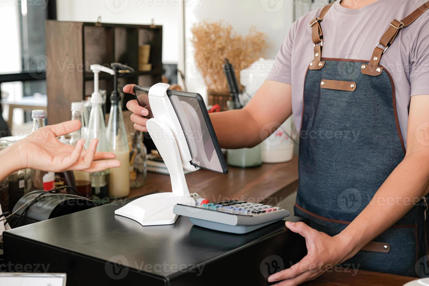 barista gebruikt het scherm om bestellingen van klanten te ontvangen. foto