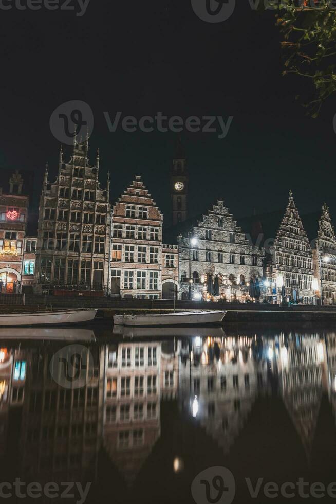 middeleeuws gebouwen Aan graslei straat in de centrum van gent door de rivier- lei gedurende de nacht. van belgië meest beroemd historisch centrum. gent waterkant gedurende middernacht foto