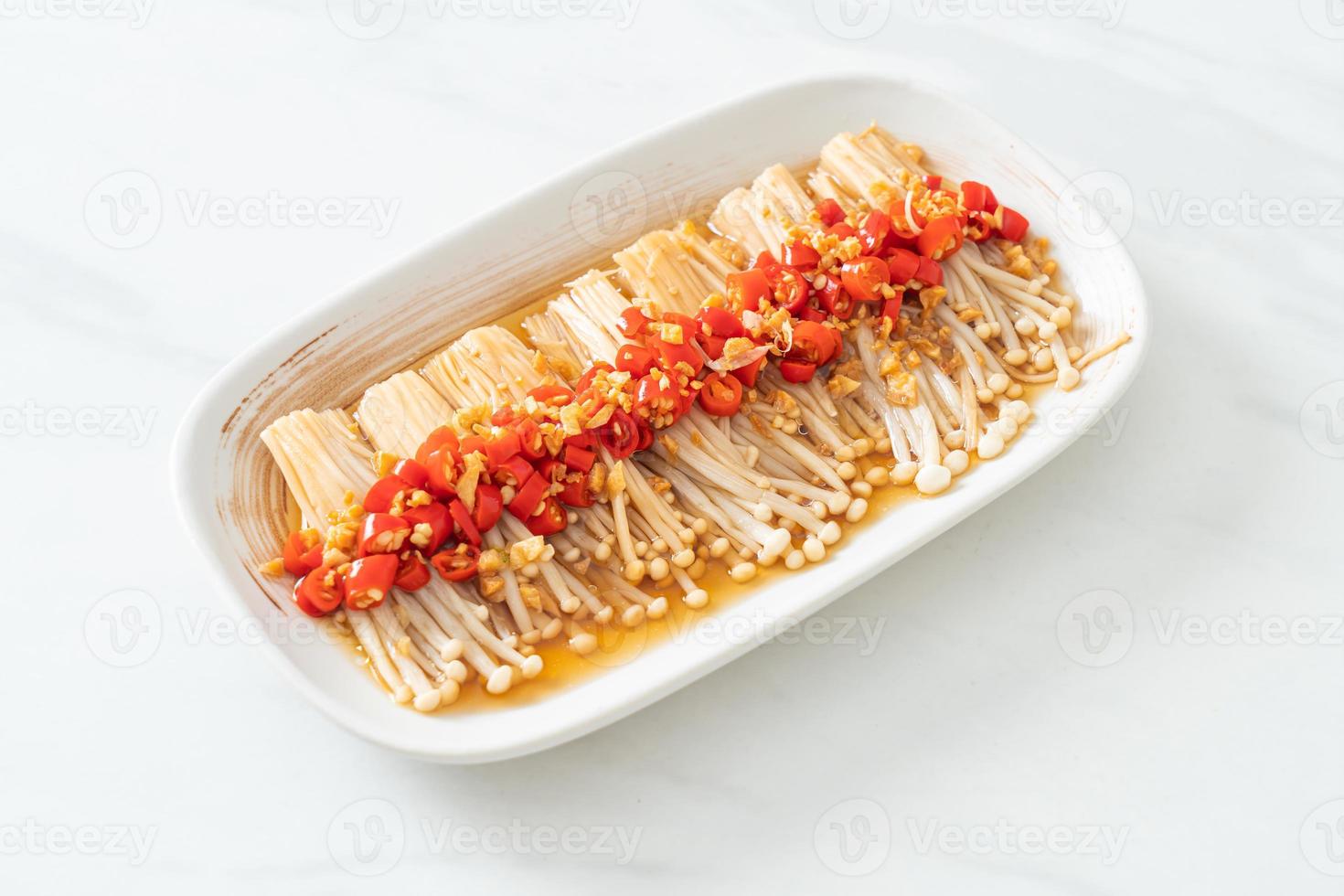 gestoomde gouden naaldpaddestoel of enokitake met sojasaus, chili en knoflook foto