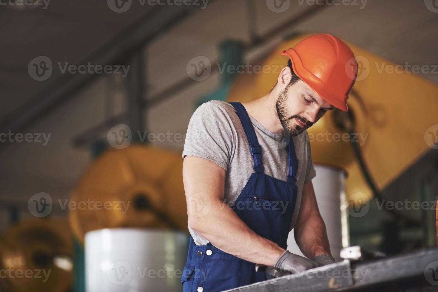 portret van een jonge meester aan het werk in een fabriek. foto