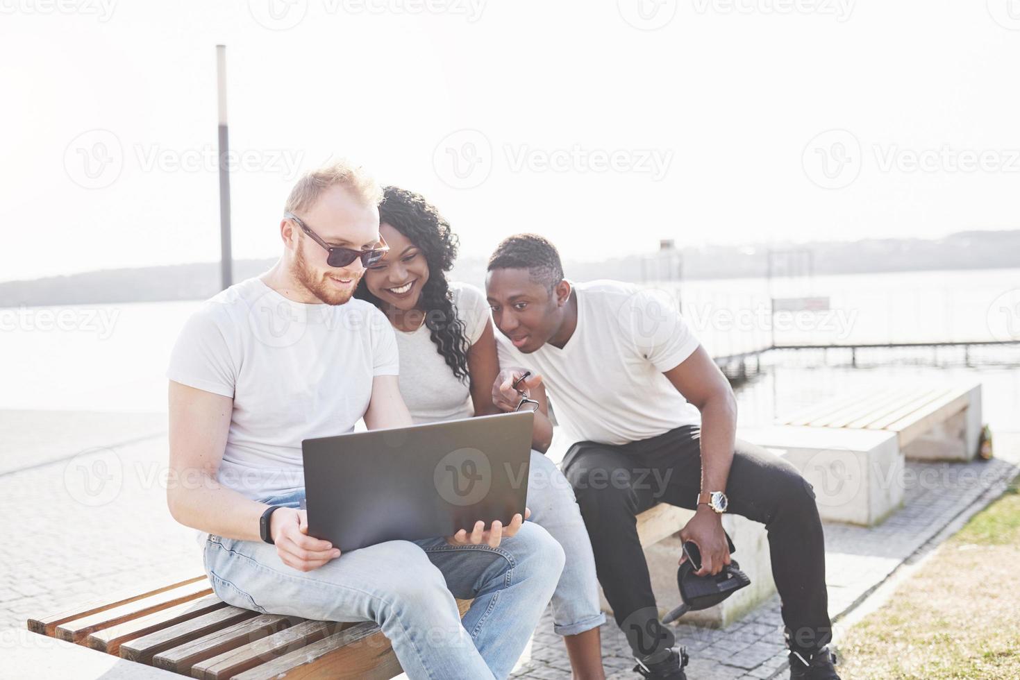 mooie multi-etnische vrienden die een laptop op straat gebruiken. jeugd levensstijl concept foto