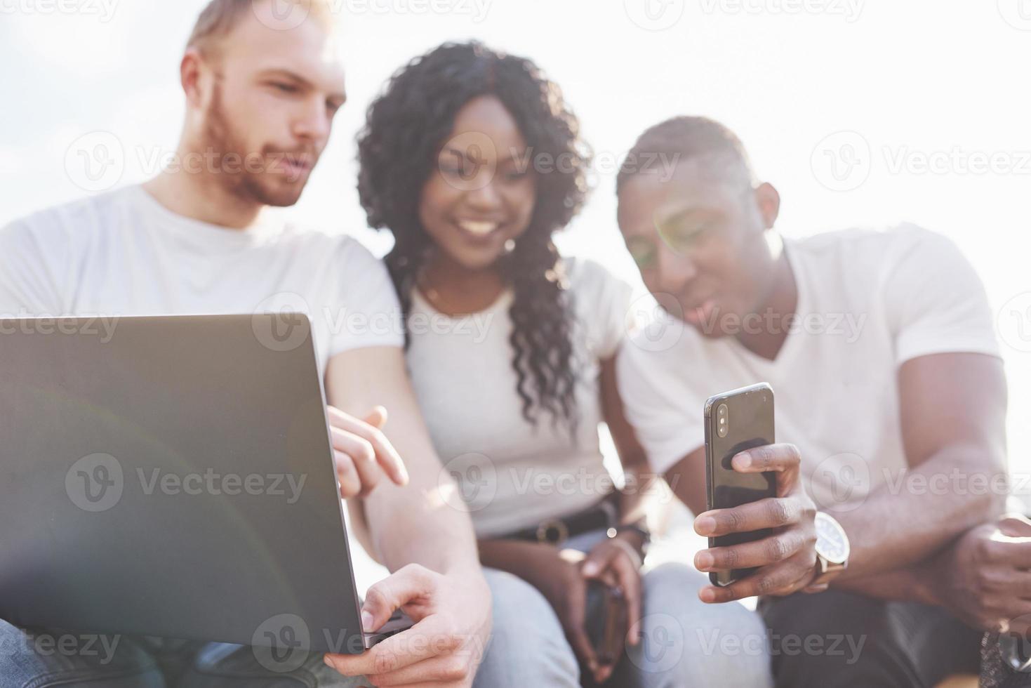 mooie multi-etnische vrienden die een laptop op straat gebruiken. jeugd levensstijl concept foto