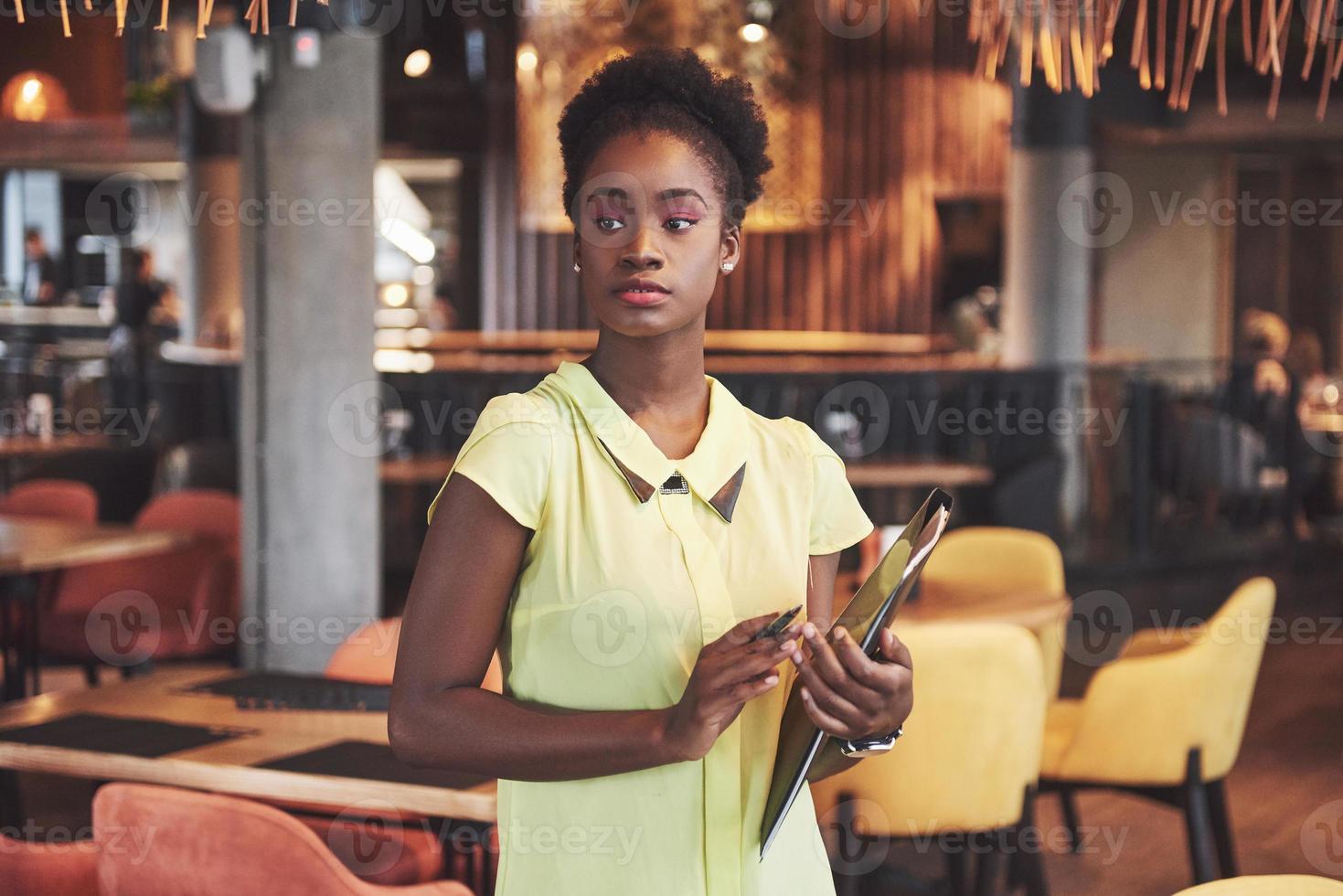 Afro-Amerikaanse zakenvrouw staat met een map in haar handen foto