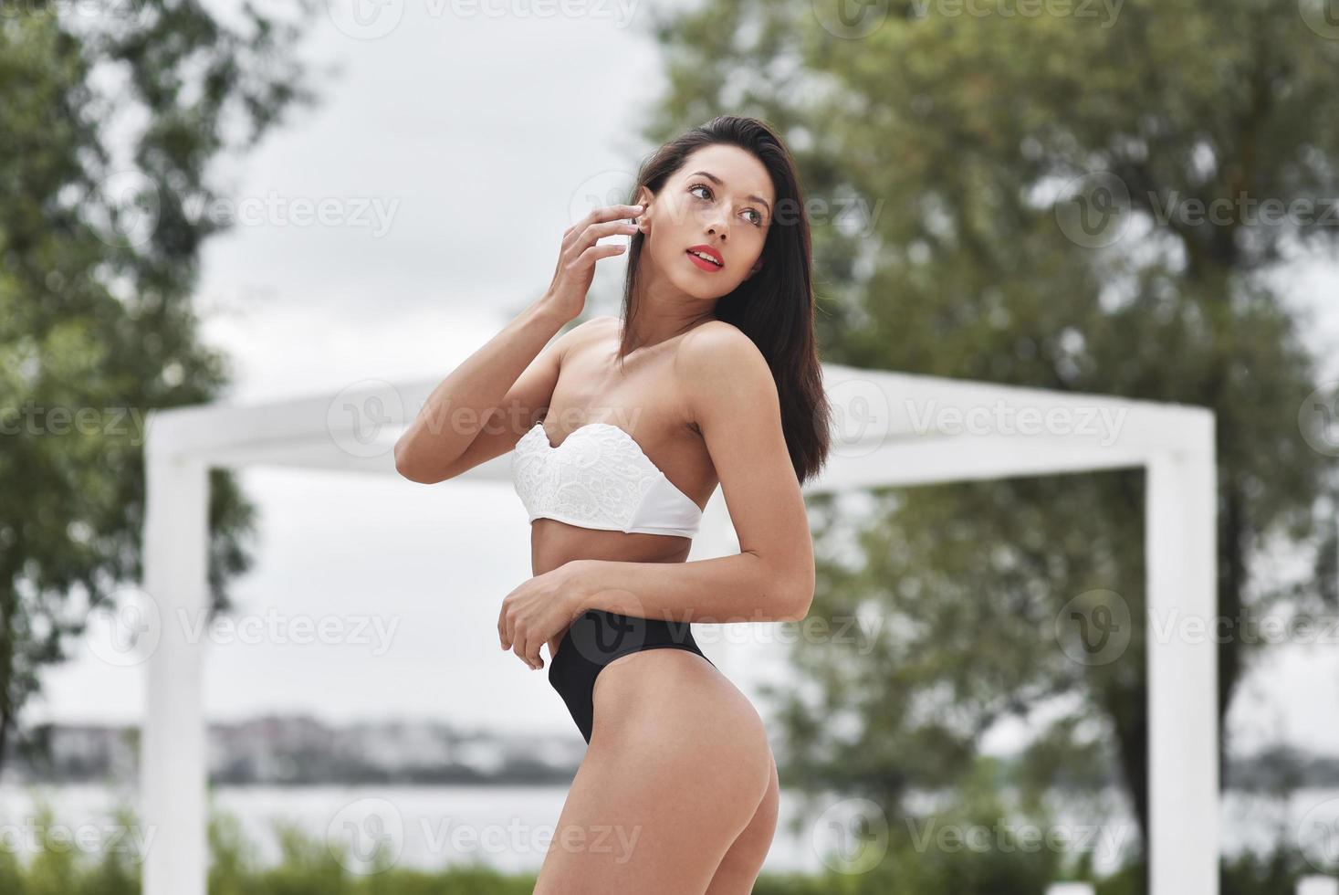 sexy jong meisje in een badpak set. mooie brunette met lang haar ontspannen op het strand. concept van sportmodel. foto