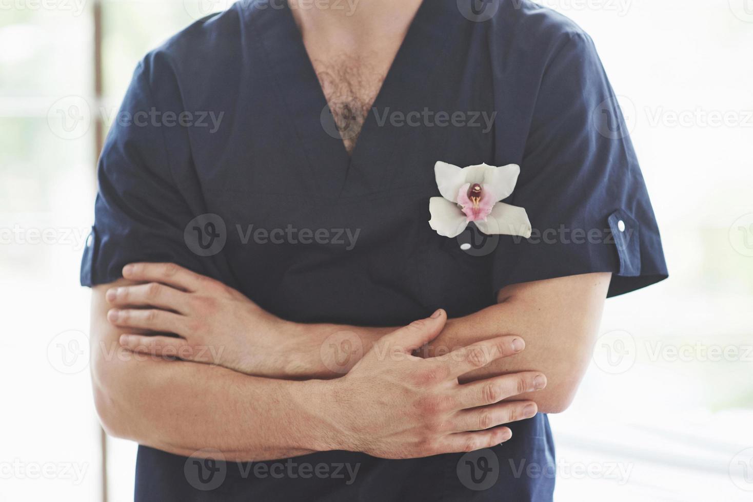 een jonge man in een donkerblauwe vorm bij een groot raam foto