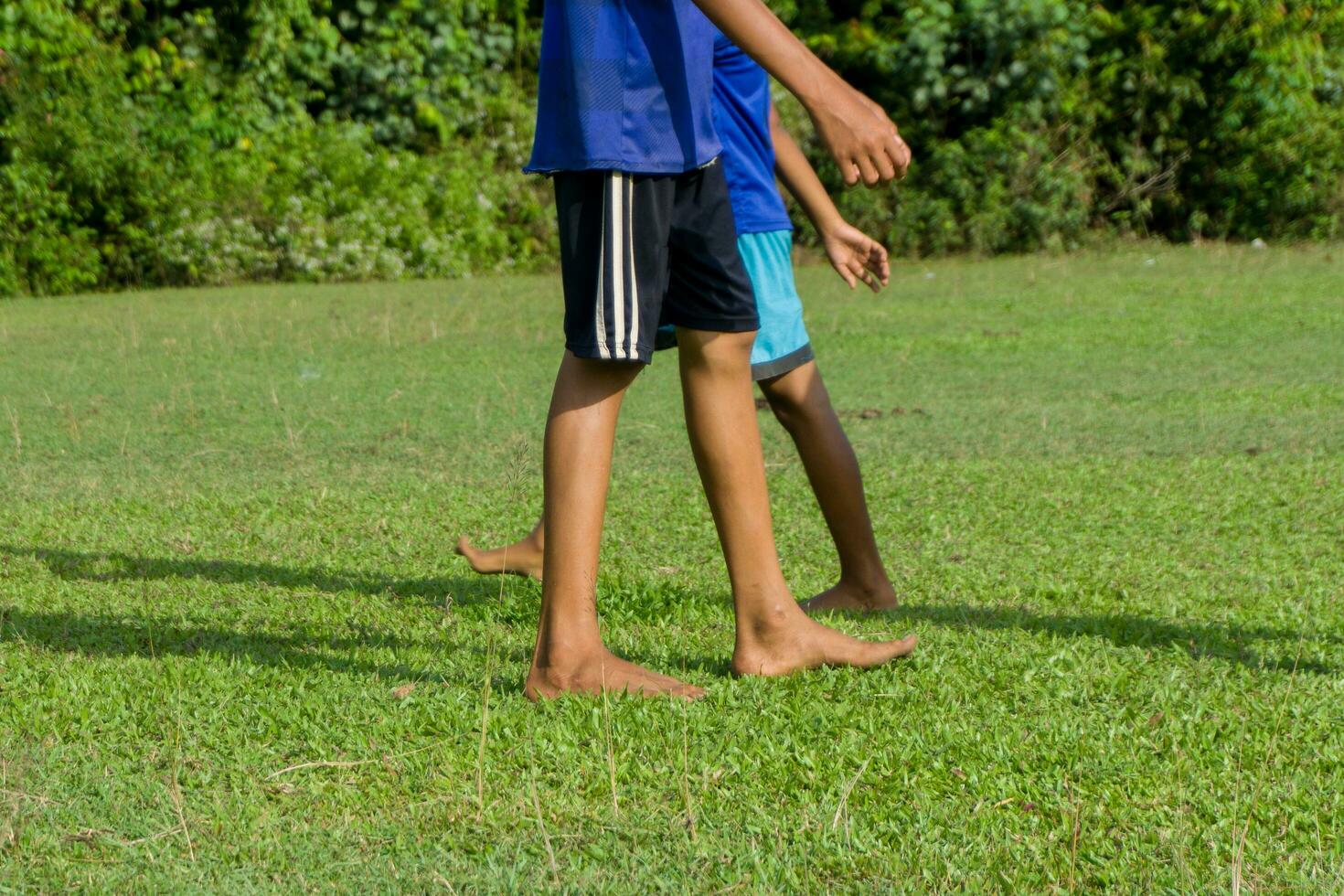 opleiding sessie in voetbal voor jeugd spelers. kinderen spelen Amerikaans voetbal in blootsvoets foto