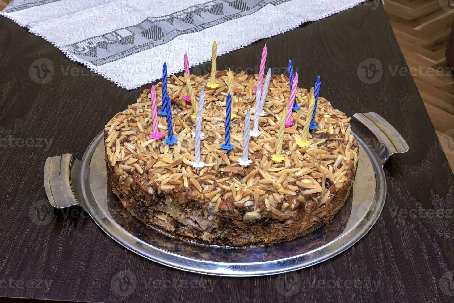 heerlijk torte voor verjaardag met kaarsen Aan de tafel. foto