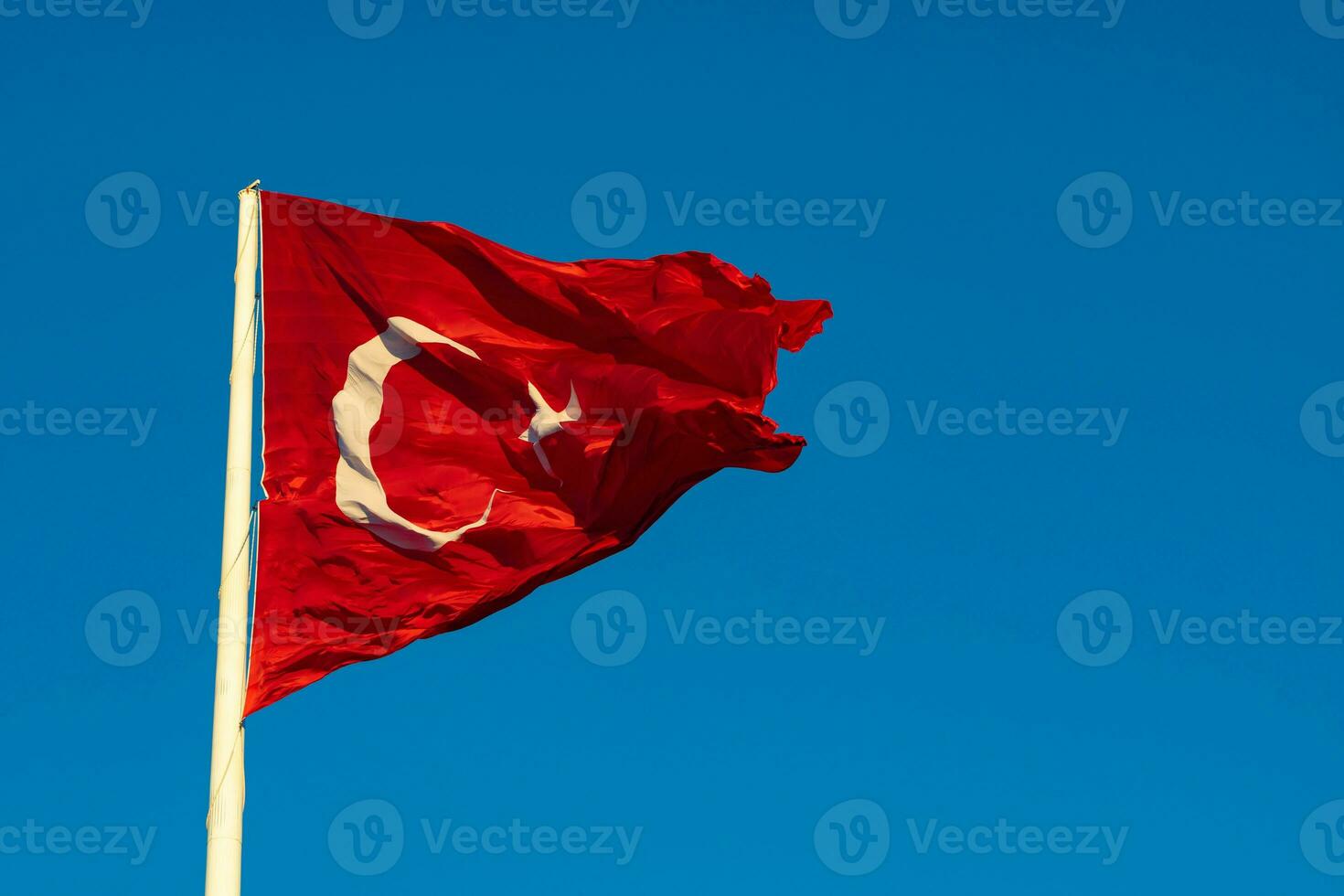 golvend Turks vlag Aan de pool geïsoleerd Aan blauw lucht achtergrond foto