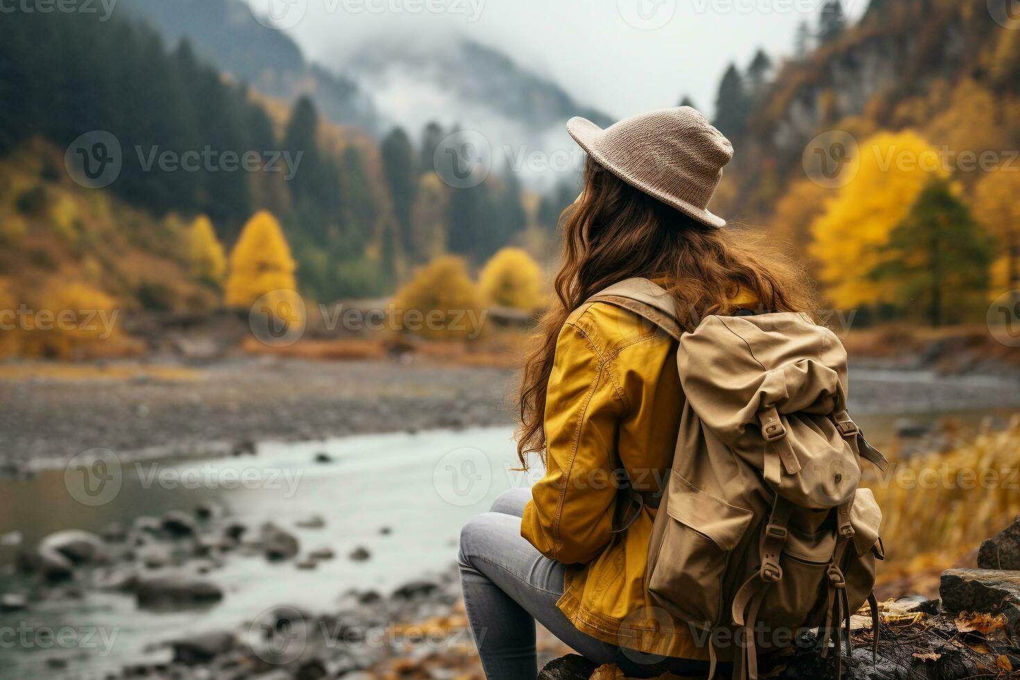 ai gegenereerd achterzijde visie van een elegant meisje, met een rugzak, een hoed en een geel jasje, op zoek Bij de visie van de bergen en de meer terwijl ontspannende in de herfst natuur. reizen concept. foto