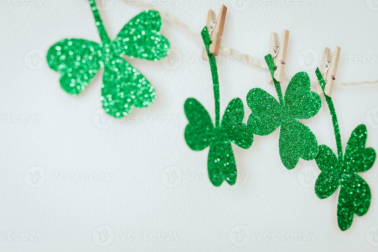 gelukkig st. patricks dag. groen schitteren klavers decoratie. eigengemaakt slinger van touw en Klaver bladeren Aan wasknijpers foto