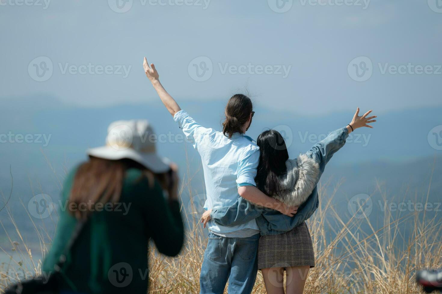 terug visie van Aziatisch Dames reiziger staand Aan top van berg en genieten natuur visie en Daar was een fotograaf nemen foto's. foto