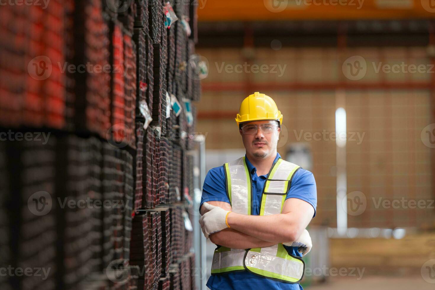 portret van een bouw arbeider staand met armen gekruiste in voorkant van staal materiaal muur foto