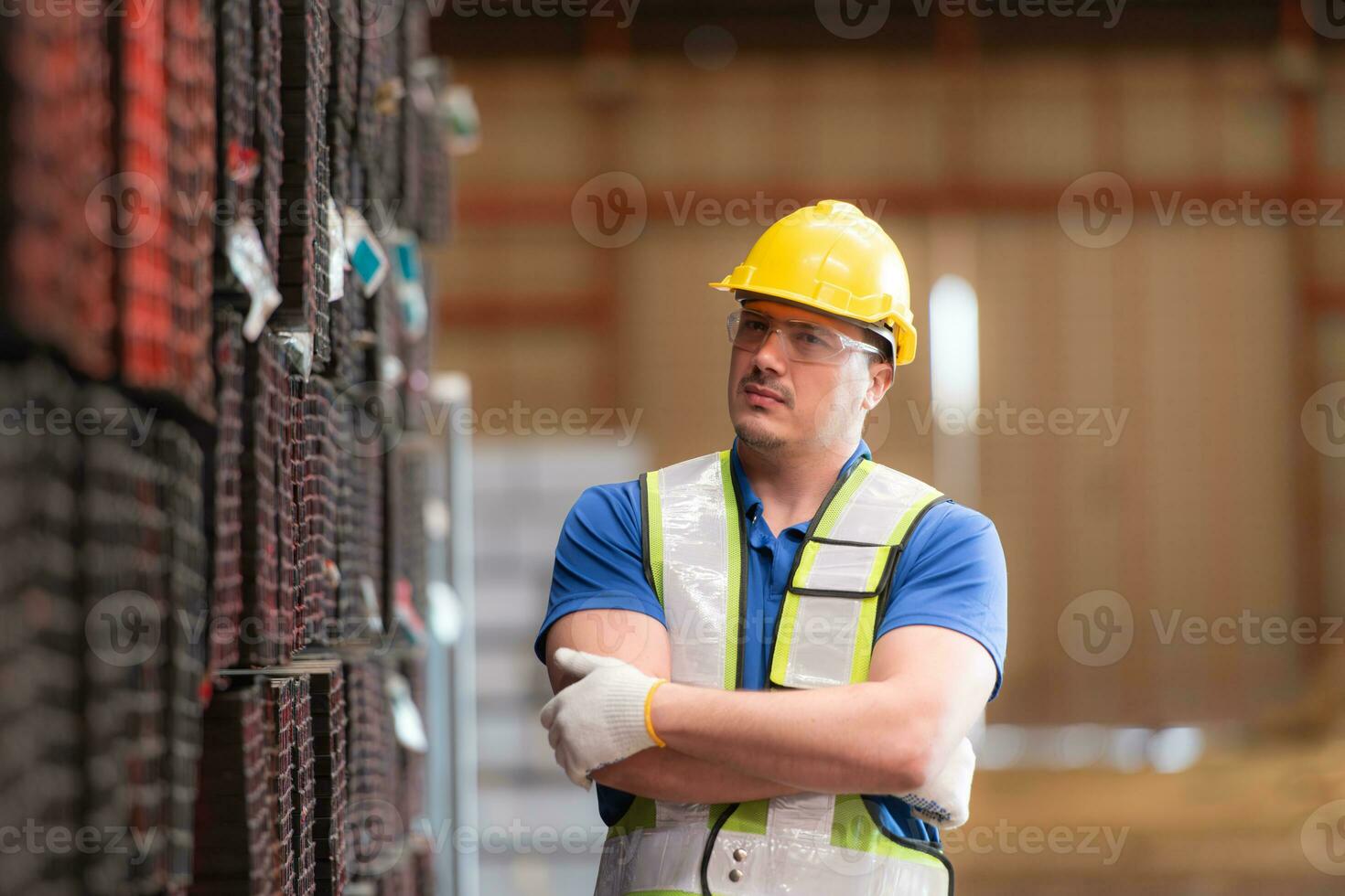 portret van een bouw arbeider staand met armen gekruiste in voorkant van staal materiaal muur foto