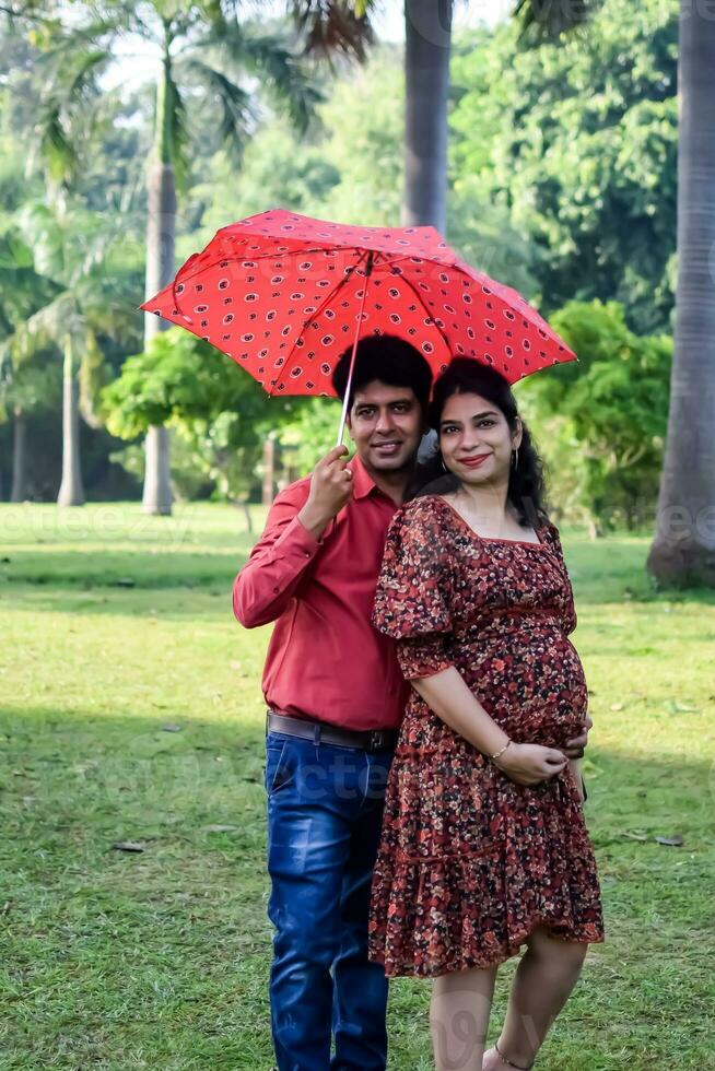 Indisch paar poseren voor moederschap schieten houding voor gastvrij nieuw geboren baby in lodhi weg in Delhi Indië, moederschap foto schieten gedaan door ouders voor gastvrij hun kind, pre baby foto schieten